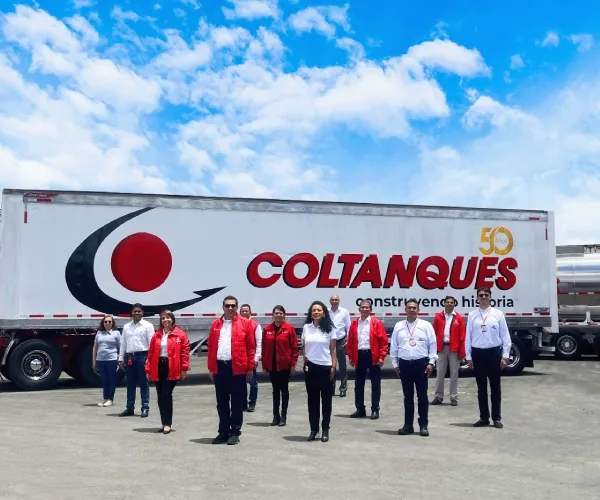 Directivos de Coltanques con chaquetas rojas frente a un tractocamión de los 50 años