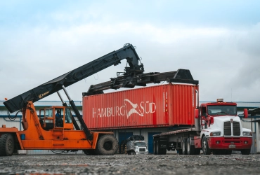 Grúa cargando un contenedor sobre un tractocamión de Coltanques