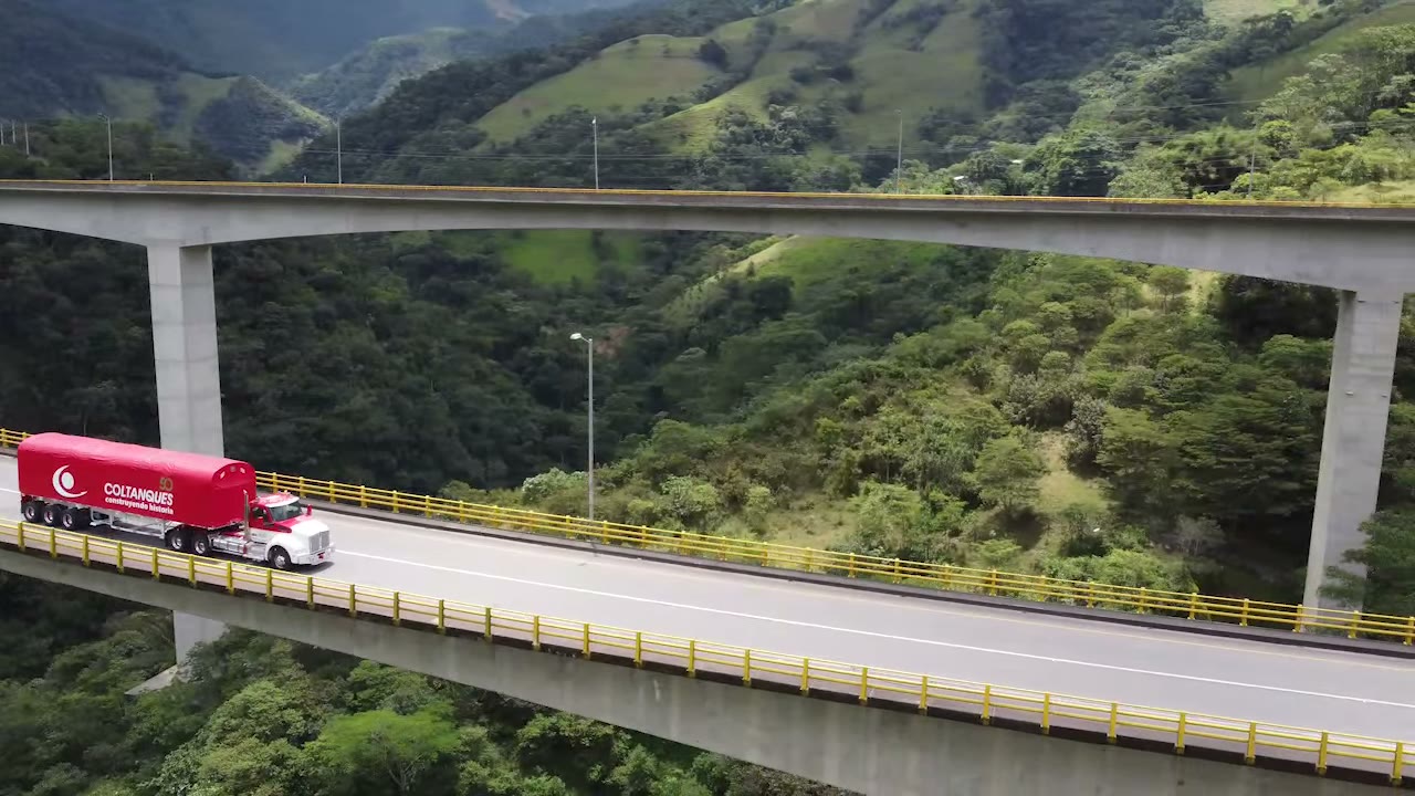 Tractocamión de Coltanques con carga seca cruzando un viaducto entre montañas